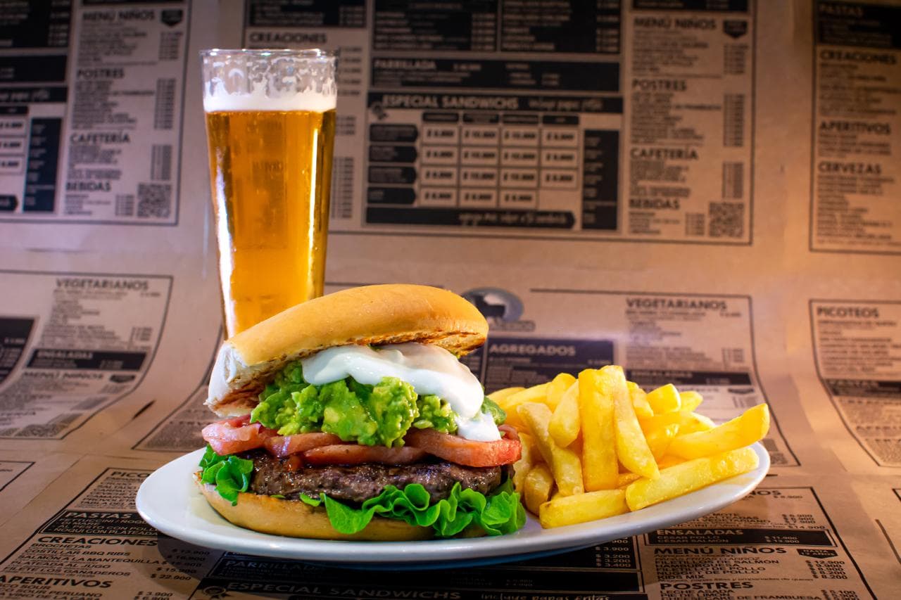 Hamburguesa italiana con palta y tomate, papas fritas y cerveza
