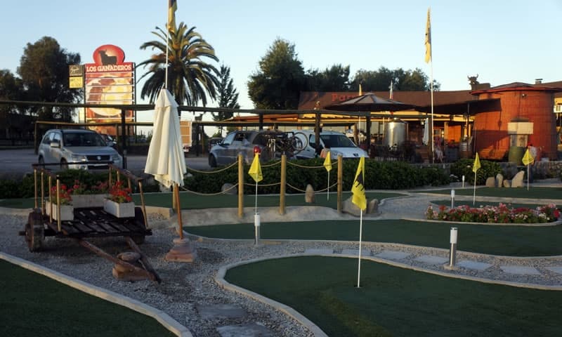 Mini golf junto al restaurante, con el letrero de Los Ganaderos al fondo